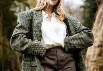 woman in gray and white polka dot blazer standing and smiling